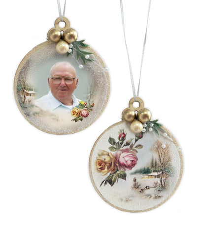 Our Memorial Christmas Ornaments were created to honor loved ones during Christmas. We take a moment to reflect back using vintage-style art and elegant accents. Round 2.75 inch wooden ornament has your personalized photo on one side and German vintage art on the other.  Each side is embellished with a soft glitter spray over the print and additional fine glitter snow. Two antique gold balls and one pearl colored ball is fastened to the top along with sprig of green and three strands of pearl. 