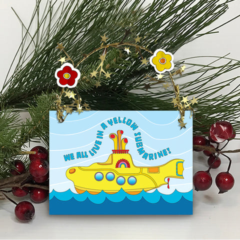 Colorful and sparkling Yellow Submarine Christmas ornament for you or your special someone! A Yellow Submarine sails the sea amid golden garland reflections. Unique one-of-a-kind ornament. Two flower heads accent a golden star-wired garland hoop affixed to the top and works perfect for hanging! Quantity pricing - 1 for 8.95, 4 for 6.74 each, and 8+ for 4.87 each. Great way to say "Merry Christmas" or "Happy Holidays" in Beatle language! tribegift.com